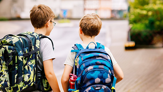 Kinder mit Schulranzen auf dem Weg zur Schule